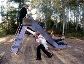 EN GÅNG TILL: Tre män i kostym, slips och dokumentportfölj åker rutschkana.

Foto: Per Johansson